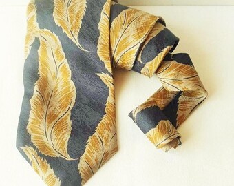 May include: A dark blue silk tie with a pattern of gold feathers.