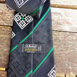 Puede incluir: Corbata negra y verde con estampado y una etiqueta blanca que dice "St. Michael Poli&eacute;ster Lavable 738/3629 Hecho en Gran Breta&ntilde;a".