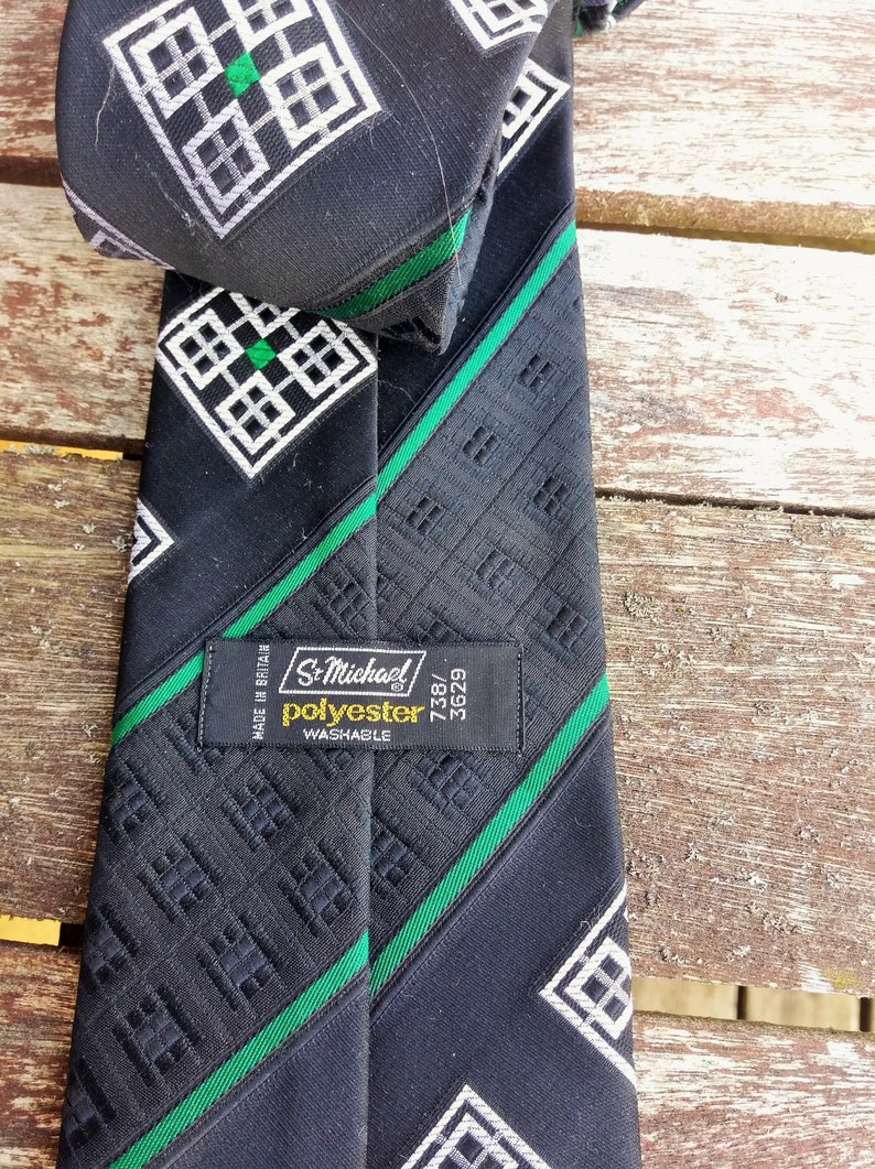 Puede incluir: Corbata negra y verde con estampado y una etiqueta blanca que dice "St. Michael Poli&eacute;ster Lavable 738/3629 Hecho en Gran Breta&ntilde;a".