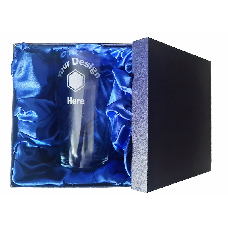 May include: A clear glass with an etched design that says "Your Design Here" inside a blue satin-lined box.