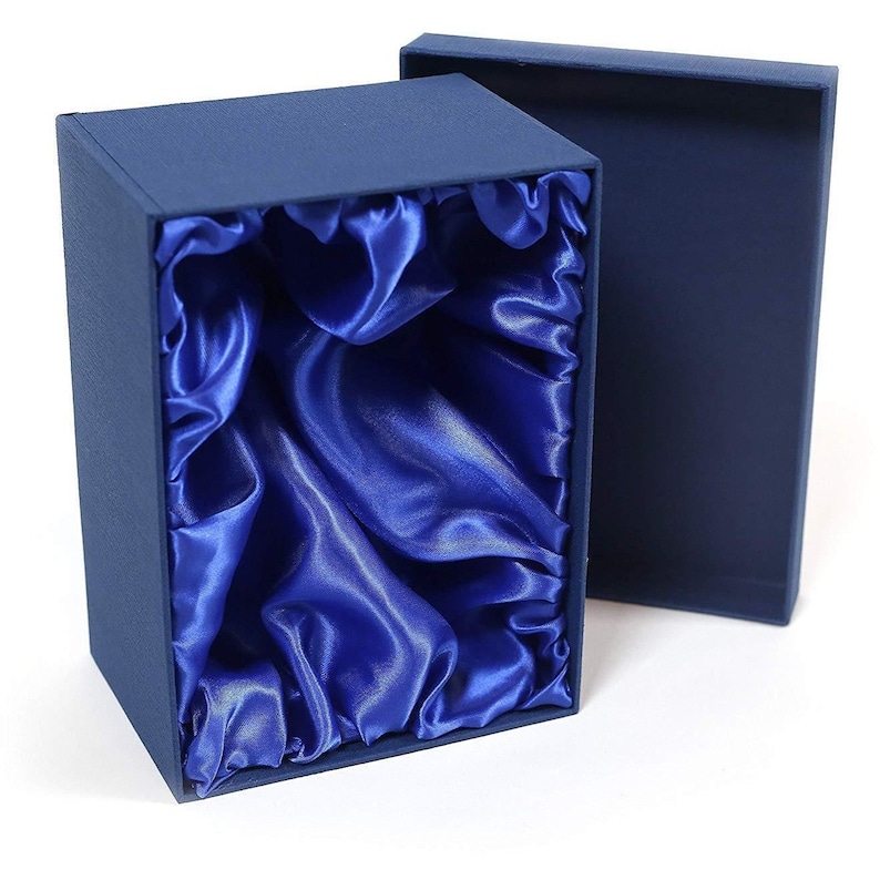 May include: A blue gift box with a satin lining. The box is open and the satin lining is visible. The box is made of cardboard and has a smooth finish.