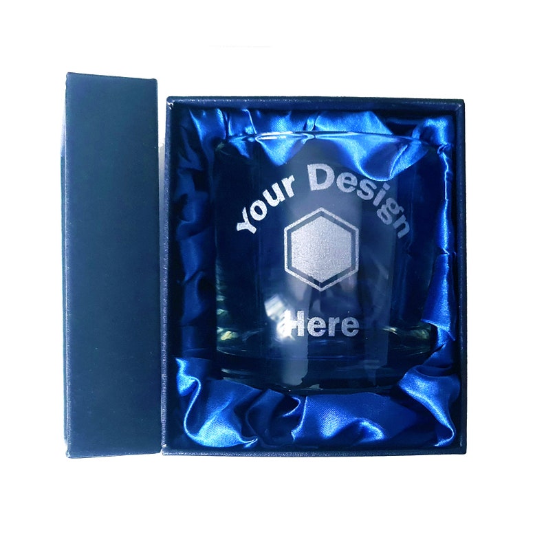 May include: A clear glass tumbler with a blue satin lining in a blue box. The glass has the words "Your Design Here" etched into it.
