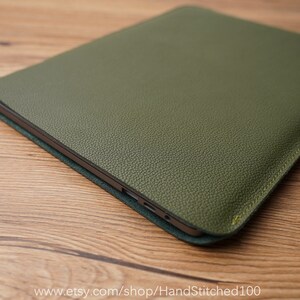 Op de afbeelding: Een groene leren laptophoes met een subtiele textuur. De hoes heeft een gestikte rand en een subtiele glans.