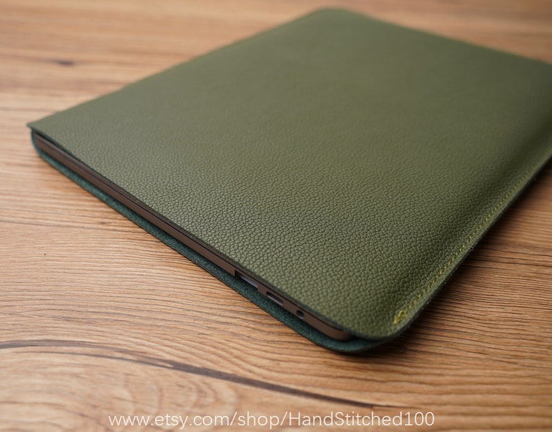 Op de afbeelding: Een groene leren laptophoes met een subtiele textuur. De hoes heeft een gestikte rand en een subtiele glans.