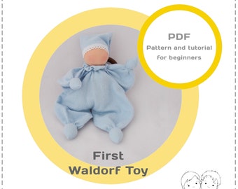 May include: PDF pattern and tutorial for beginners to make a first Waldorf toy. The pattern includes instructions for a blue baby doll with a white bonnet and brown hair. The doll is lying on a light gray surface. The text "First Waldorf Toy" is below the doll. The text "Genuine Dolls" is below the text "First Waldorf Toy".