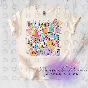 May include: A cream-coloured t-shirt featuring the text "MY FAVORITE DISNEY PRINCESSES CALL ME MAMA" in a retro font. The design incorporates illustrations of Disney princesses and a castle.