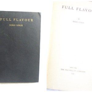 May include: A black hardcover book titled "Full Flavour" by Doris Leslie. The book cover has gold lettering. The back cover of the book is white with the text "Full Flavour" by Doris Leslie. The text "The Macmillan Company" is printed on the back cover.