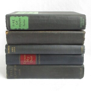 May include: A stack of six vintage hardcover books with black covers and gold lettering. The titles include "Fire of Youth", "Polonaise", "Excuse My Dust", and "Full Flavour".