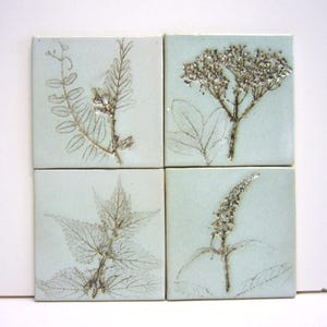 4 handmade tiles with imprints of flowers, highfired ceramic, 10x10 cm each