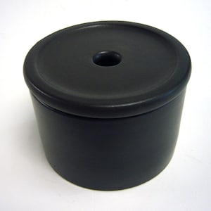 May include: A black ceramic jar with a lid. The lid has a small hole in the center.
