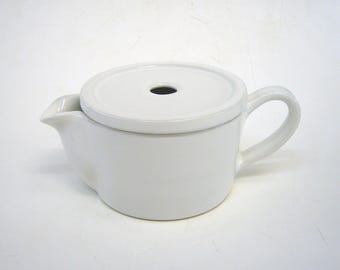 May include: White ceramic creamer with a lid and a handle. The lid has a small hole in the center.