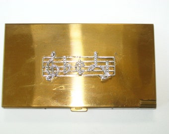 Bolso de mano Volupte Musical Goldtone & Rhinestone; Estuche de maquillaje compacto con espejo todo en uno con borla + estuche para lápiz labial - Clave de sol con mecanismo Reuge