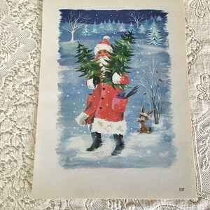 May include: A vintage Christmas card depicting a red-suited Father Christmas carrying a small Christmas tree in a snowy winter scene. A small rabbit stands to the right of Father Christmas.
