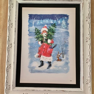 May include: A framed illustration of Father Christmas carrying a Christmas tree in a snowy forest. The illustration is in a white frame with a black mount. The number 107 is printed in the bottom right corner of the illustration.