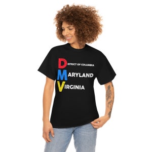 May include: Black t-shirt with the letters "DMV" in red, blue, and yellow, with the words "DISTRICT OF COLUMBIA", "MARYLAND", and "VIRGINIA" printed in white. The shirt is worn by a person.
