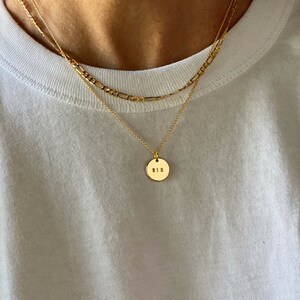 May include: A gold chain necklace with a round pendant that says "818" on it.