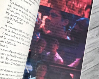 May include: An open book with black printed text on the left page and a semi-transparent overlay on the right page. The overlay features a dark, moody photograph of people in a dimly lit club with red and blue lighting, partially obscuring the text.