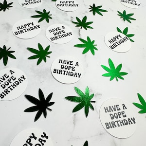 May include: White round confetti with black text that says "Happy Birthday" and "Have a Dope Birthday". Green marijuana leaf confetti.
