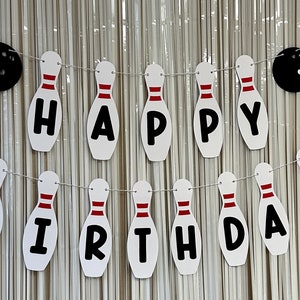 May include: A white and red bowling pin banner that says "Happy Birthday".