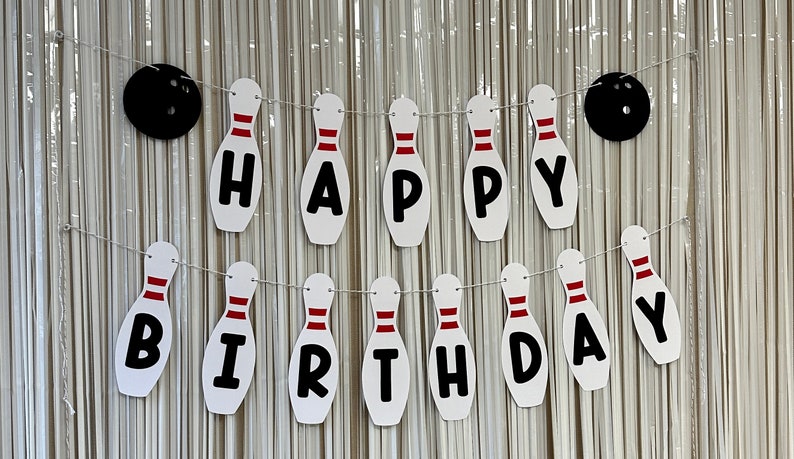 May include: A white and red bowling pin banner that says "Happy Birthday".