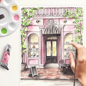 May include: Watercolor painting of a pink storefront with a sign that reads "Patisserie". The storefront has a large window display filled with pastries and a black door with a glass window. There is a small table and chairs outside the store.