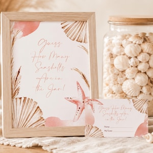 Puede incluir: Un marco de madera clara que contiene un letrero con el texto Guess How Many Seashells Are in the Jar! decorado con conchas marinas y una estrella de mar en acuarela, junto a una tarjeta de juego a juego y un frasco de vidrio con conchas.