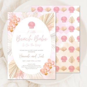 May include: A pink and beige baby shower invitation with a seashell and palm leaf design. The text reads "A Little Beach Babe Is On The Way" and includes the names "Hannah and Joel".
