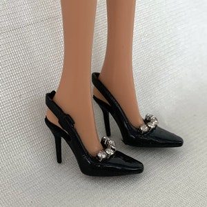 May include: A pair of black high-heeled shoes with a slingback strap and rhinestones on the toe.