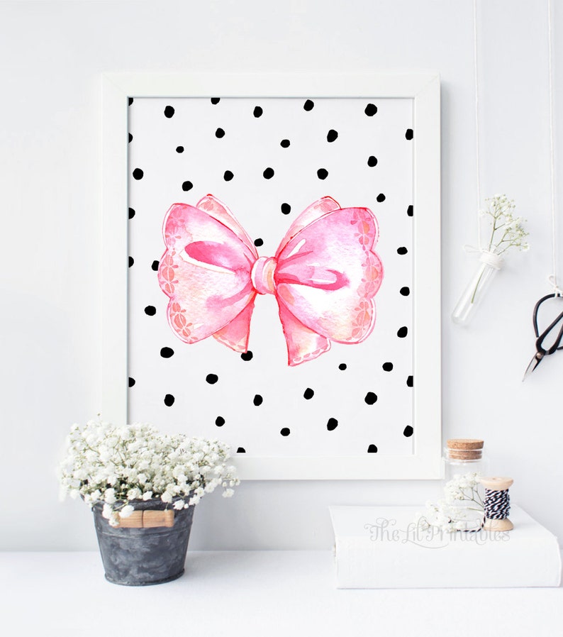 May include: A pink watercolor bow with a white polka dot background. The bow has a scalloped edge and is tied with a white ribbon. The background is white with black polka dots.