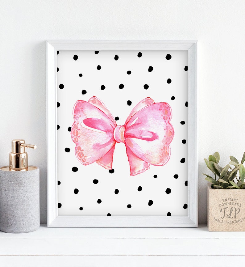 May include: A printable art print featuring a pink watercolor bow on a white background with black polka dots.