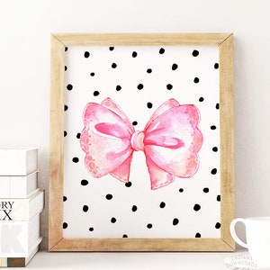 May include: A printable art print featuring a pink watercolor bow on a white background with black polka dots.