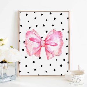 May include: A pink watercolor bow with a white polka dot background. The bow has a lace-like design and is tied in a knot. The background is white with black polka dots.