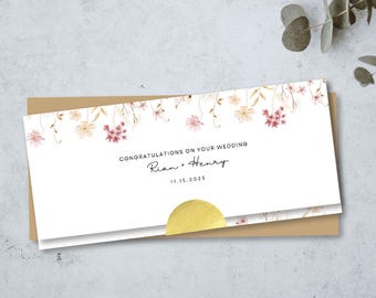 May include: A rectangular wedding card with a white background featuring a watercolor floral border of pink and tan flowers at the top. The text reads CONGRATULATIONS ON YOUR WEDDING, Rian + Henry, and 11.15.2025. A gold circular seal is at the bottom.