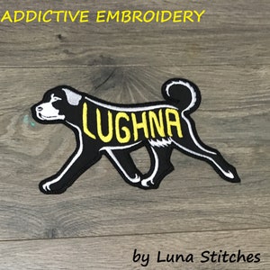 May include: Black and white embroidered dog patch with the name "LUGHNA" in yellow lettering. The patch is on a woodgrain background. By Luna Stitches.
