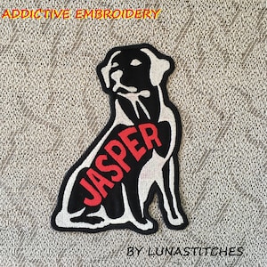May include: Black and white embroidered patch of a dog with the name "Jasper" in red lettering. The patch is on a brown fabric background.