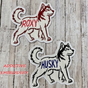 Può includere: Due toppe ricamate bianche di cani husky. La toppa superiore ha il nome "ROXY" ricamato in rosso. La toppa inferiore ha il nome "HUSKY" ricamato in blu.