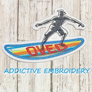 May include: Embroidered patch of a person surfing on a surfboard with the word "Loved" written on it in red. The surfboard has a blue, yellow, and orange striped design. The patch is white with a blue border.