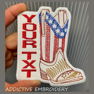 May include: Embroidered patch featuring a white cowboy boot with red and blue accents, and a vertical rectangle with the text "YOUR TXT" in red. The boot design includes stars and stripes, and the text "ADDITIVE EMBROIDERY" is at the bottom.