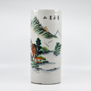 May include: White ceramic vase with a painted landscape scene of mountains, trees, and a river. The vase has Chinese characters that read "山有清泉".