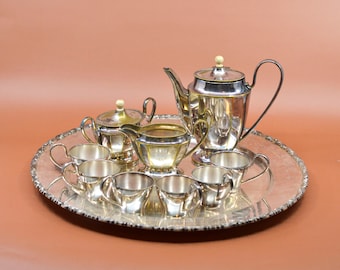 May include: A silver tea set with a teapot, creamer, sugar bowl, and six cups on a silver tray.