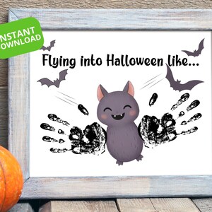 Puede incluir: Un estampado enmarcado con temática de Halloween con un murciélago de dibujos animados sonriente. El murciélago tiene alas de huellas de manos y el texto "Flying into Halloween like..." está encima. Una pegatina verde dice "INSTANT DOWNLOAD".