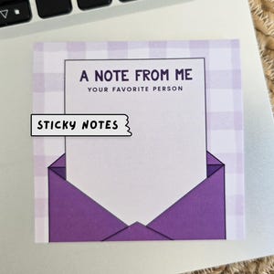 Könnte beinhalten: Ein Haftnotizblock mit weißen und violetten Karos mit dem Text "A Note From Me Your Favorite Person" und den Worten "Sticky Notes" in einem schwarzen Banner oben.