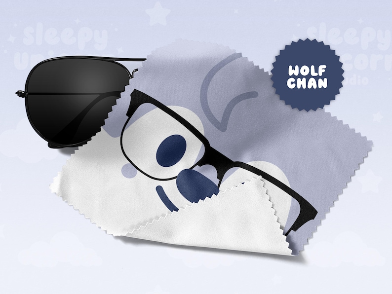 May include: Black aviator sunglasses rest on a white and blue microfiber cloth with a cartoon wolf face and the text "WOLF CHAN". The cloth is partially covering the sunglasses. The background is light blue with white stars.