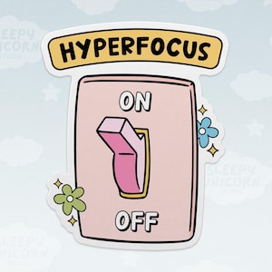 May include: A die-cut sticker featuring a light pink light switch plate with a pink toggle switch set to the ON position. The word HYPERFOCUS is printed in black on a yellow banner above the switch, with ON and OFF labels and small flowers.