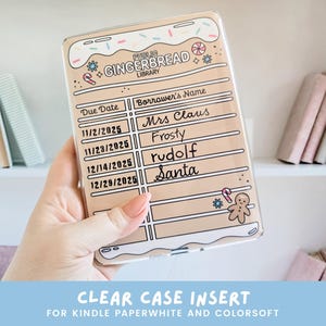 May include: Clear case insert for Kindle Paperwhite and Colorsoft, featuring a gingerbread library design. The case has a tan background with a white frosting border and decorative elements. The text includes "Due Date" and "Borrower's Name" with names like "Mrs. Claus" and "Santa".