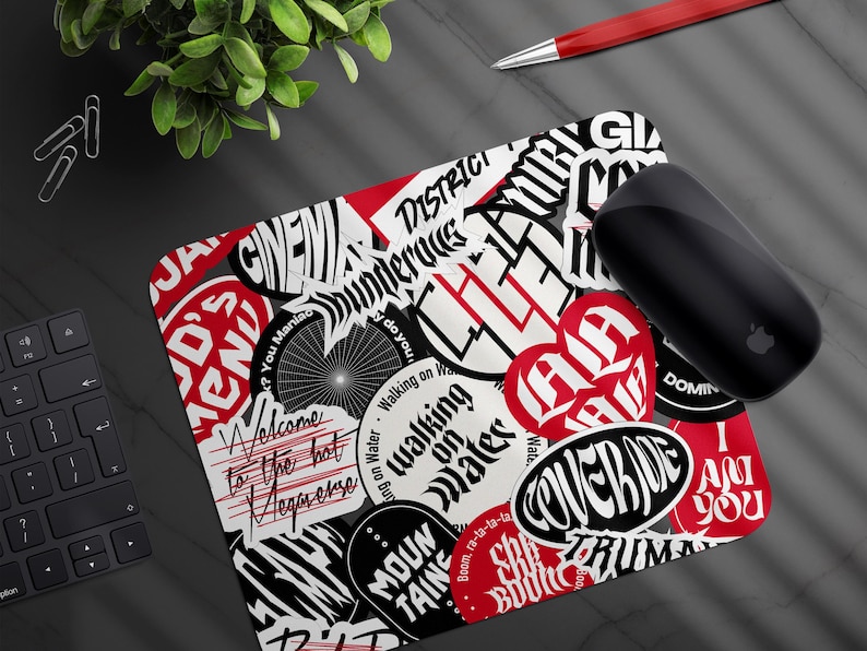 May include: A rectangular mousepad with a collage of black, white, and red sticker designs. The mousepad features various text elements, including "Welcome to the hot Megaverse" and "Walking on Water."
