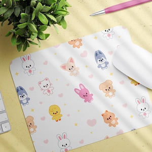 May include: White mousepad with a repeating pattern of cartoon animals, including bunnies, cats, and dogs, with pink hearts and yellow stars. A white computer mouse and keyboard are also visible.