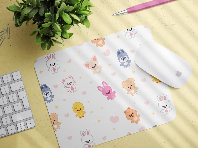 May include: White mousepad with a repeating pattern of cartoon animals, including bunnies, cats, and dogs, with pink hearts and yellow stars. A white computer mouse and keyboard are also visible.