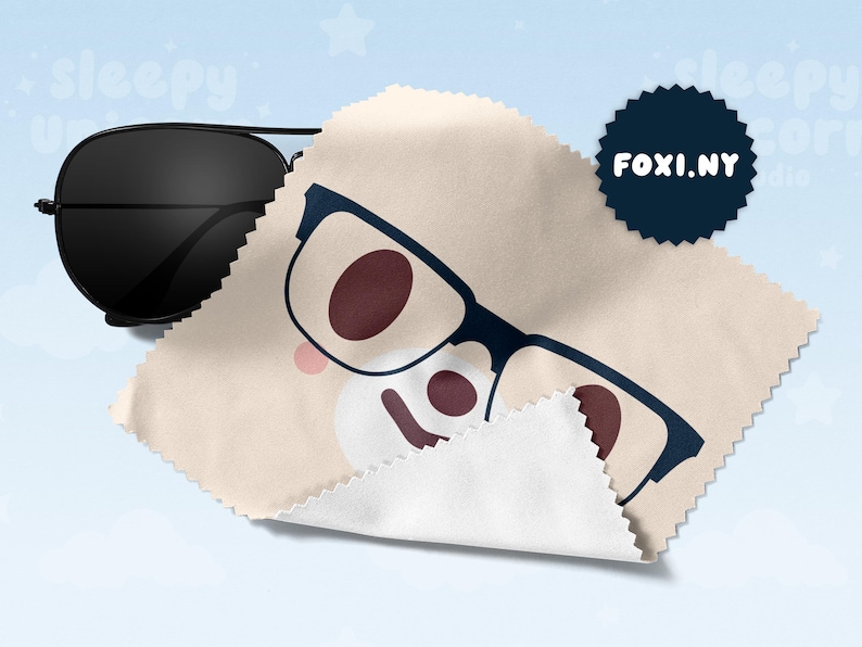 May include: Black aviator sunglasses next to a beige microfiber cleaning cloth with a cartoon glasses design. A navy blue circular logo with the text "FOXI.NY" is also visible.