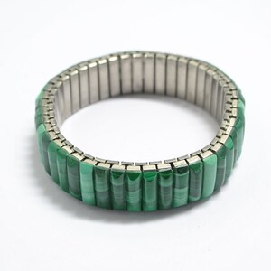 May include: A green malachite stone bracelet with a silver expandable band.